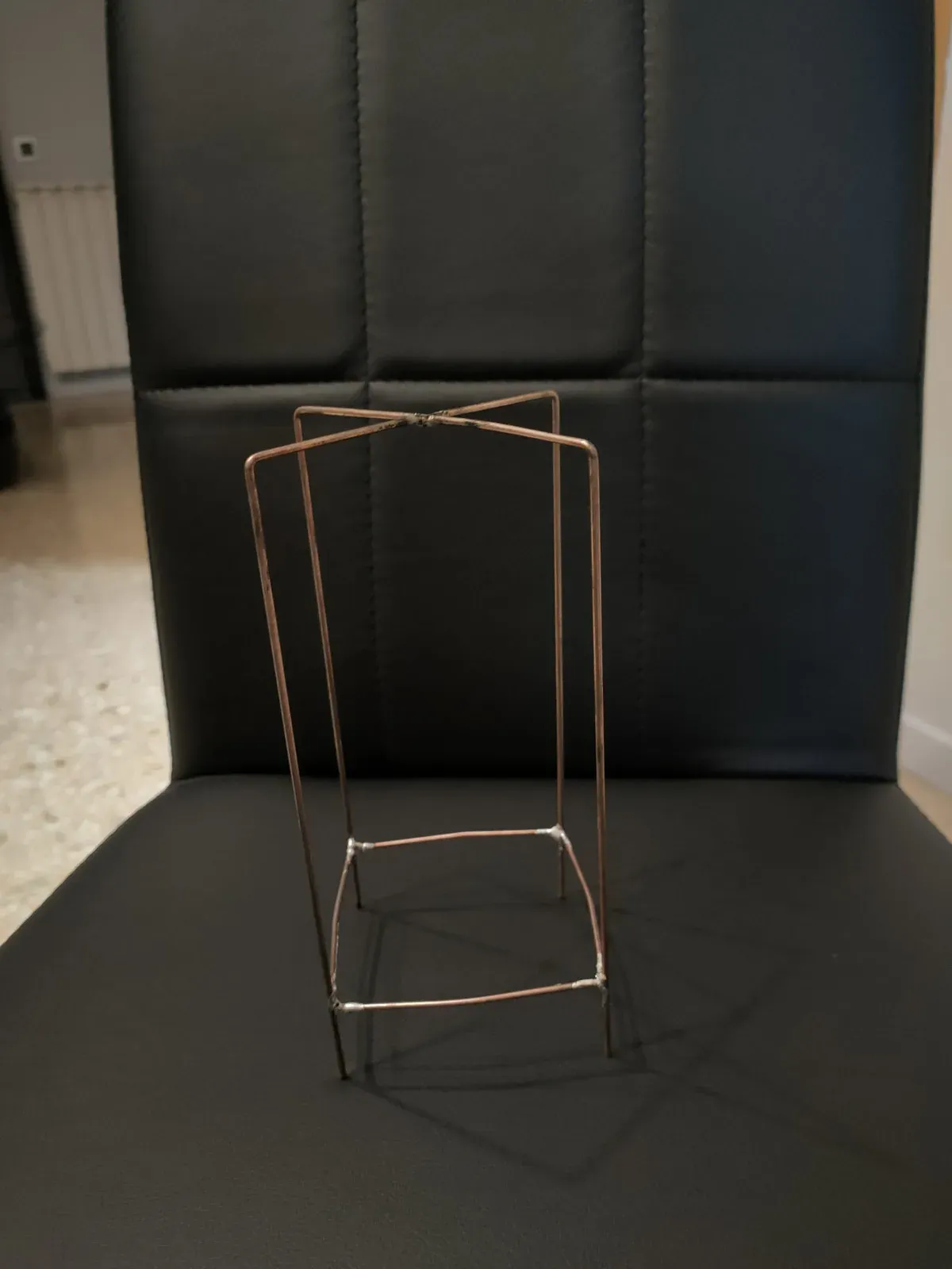 Primera rejilla externa de latón, sobre una silla