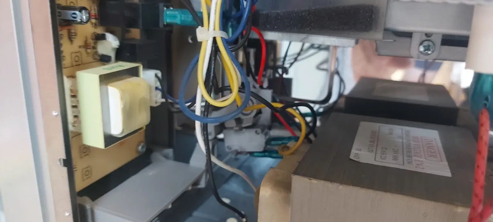 Interior del microondas desmontado con el transformador a la vista